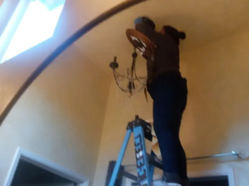 Electrician installing a chandelier in a Elk Grove residence